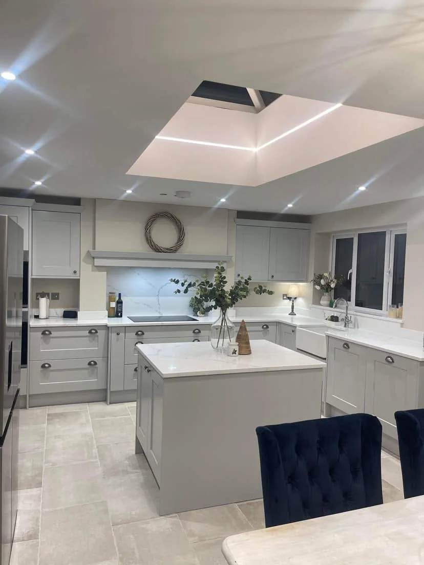 Open-plan kitchen with recessed downlights, a lit roof lantern and under-cabinet lighting